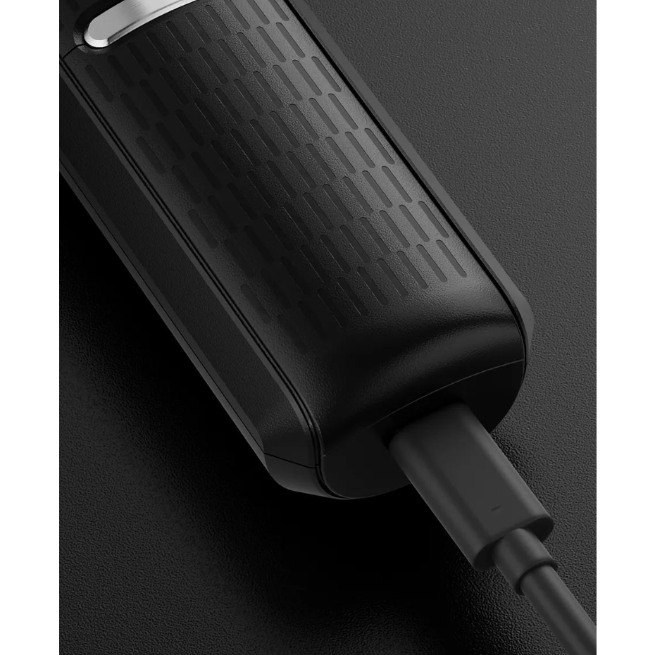 Black body groomer on a textured surface and cable on a dark background