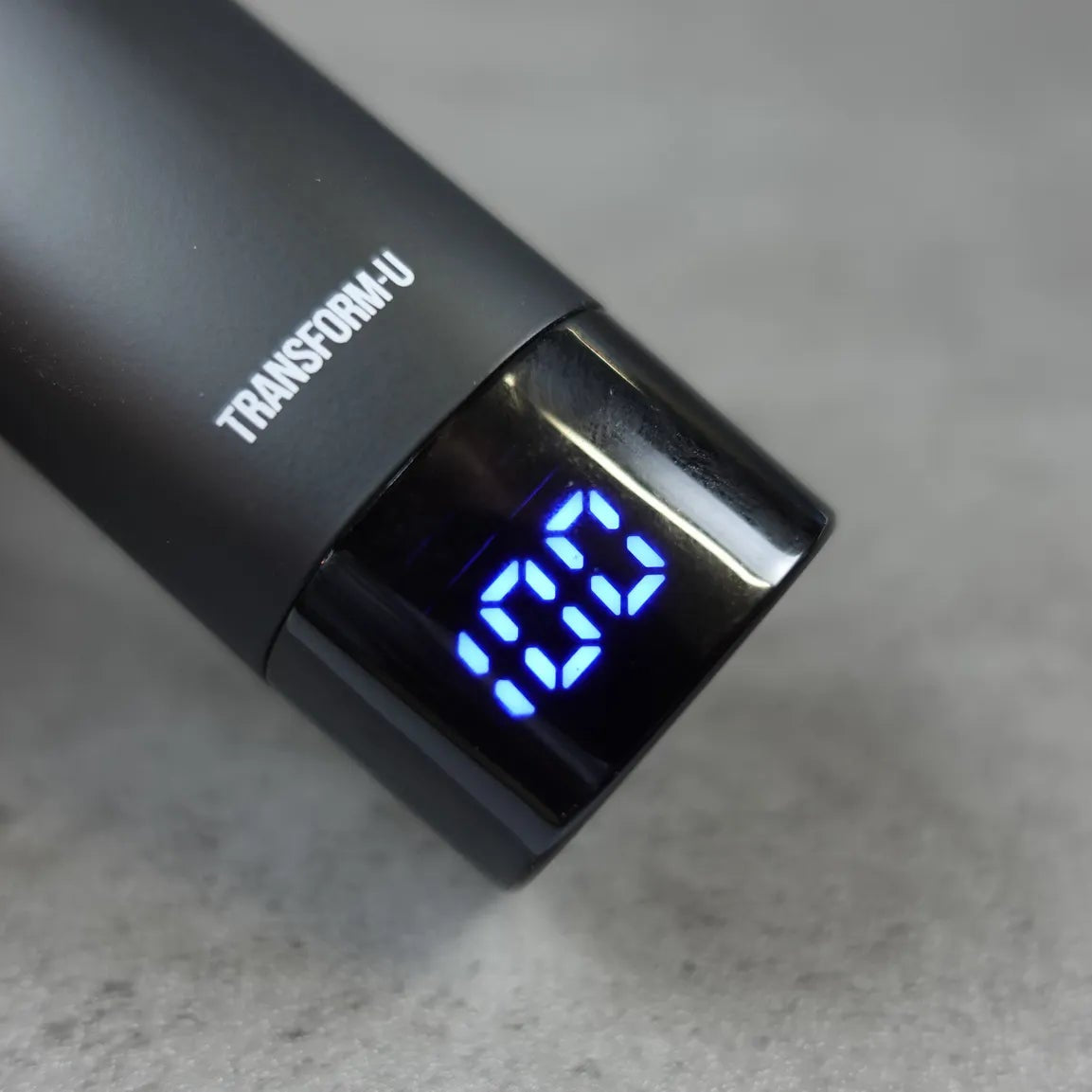 Black nose and ear hair trimmer with digital display on a gray surface