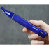 Hand holding a blue nose and ear trimmer hair device labeled 'TRANSFORM-U' against a gray background