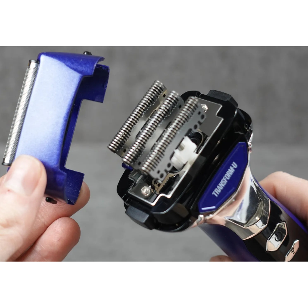 Close-up of a TRANSFORM-U shaver with a person holding it against a gray background