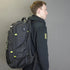 Person wearing a black backpack with a gray background