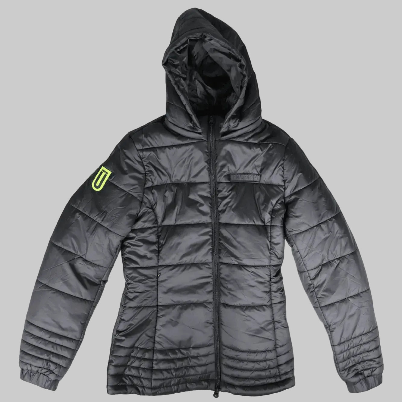 A dark gray hooded puffer jacket with horizontal quilting, a front zipper, and a bright neon yellow geometric logo patch on the left sleeve, shown against a solid black background.