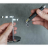 Person holding a metal safety razor stand against a gray background