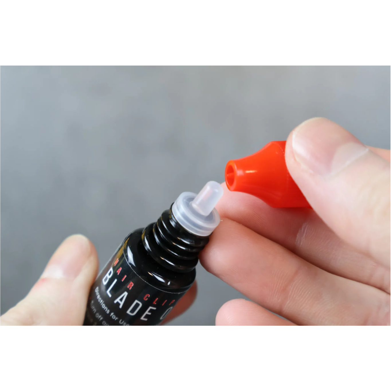 blade oil cap held by hands with red cap