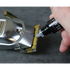 Person using blade oil on a hair clipper against a gray background