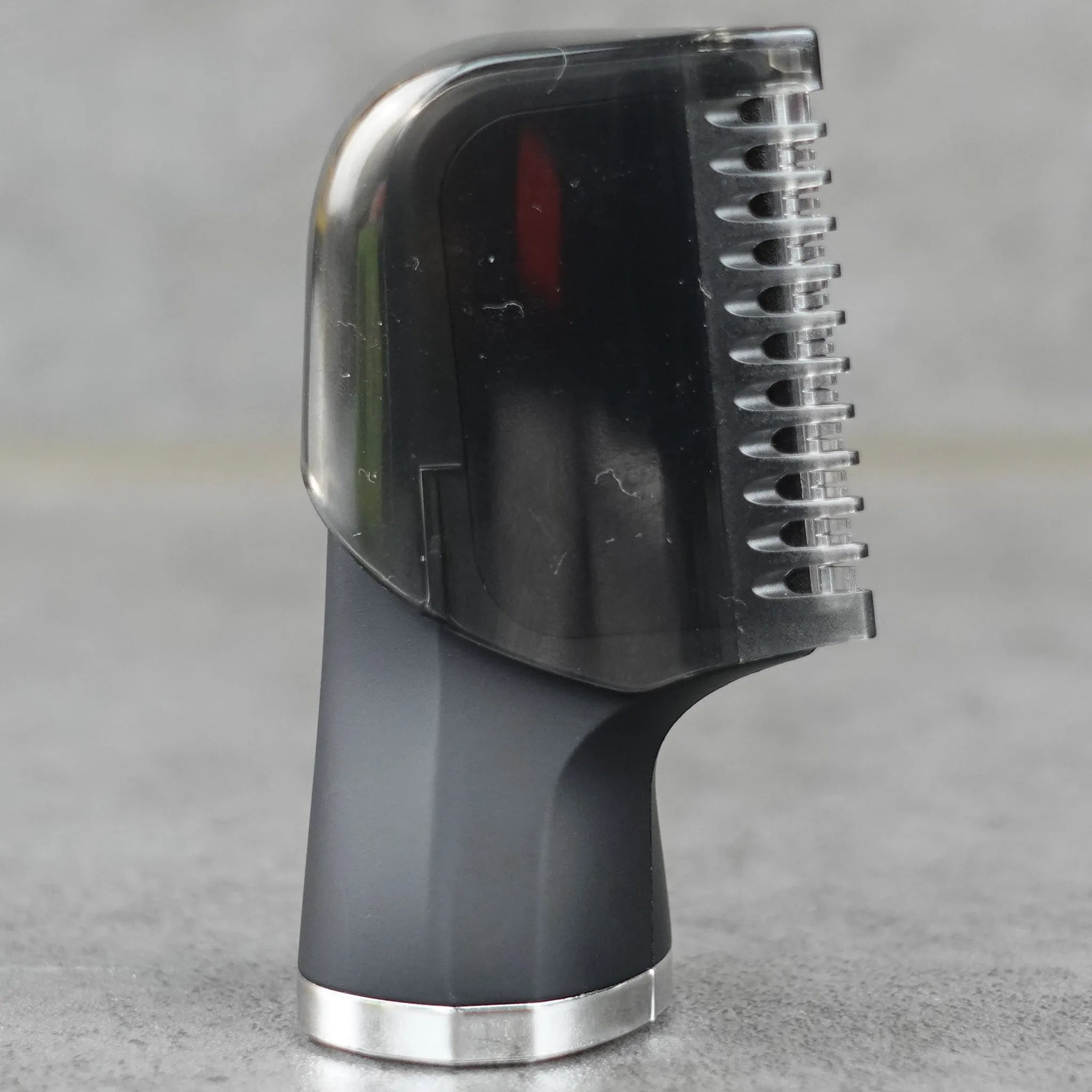 Black sensitive body groomer head attachment on a gray background