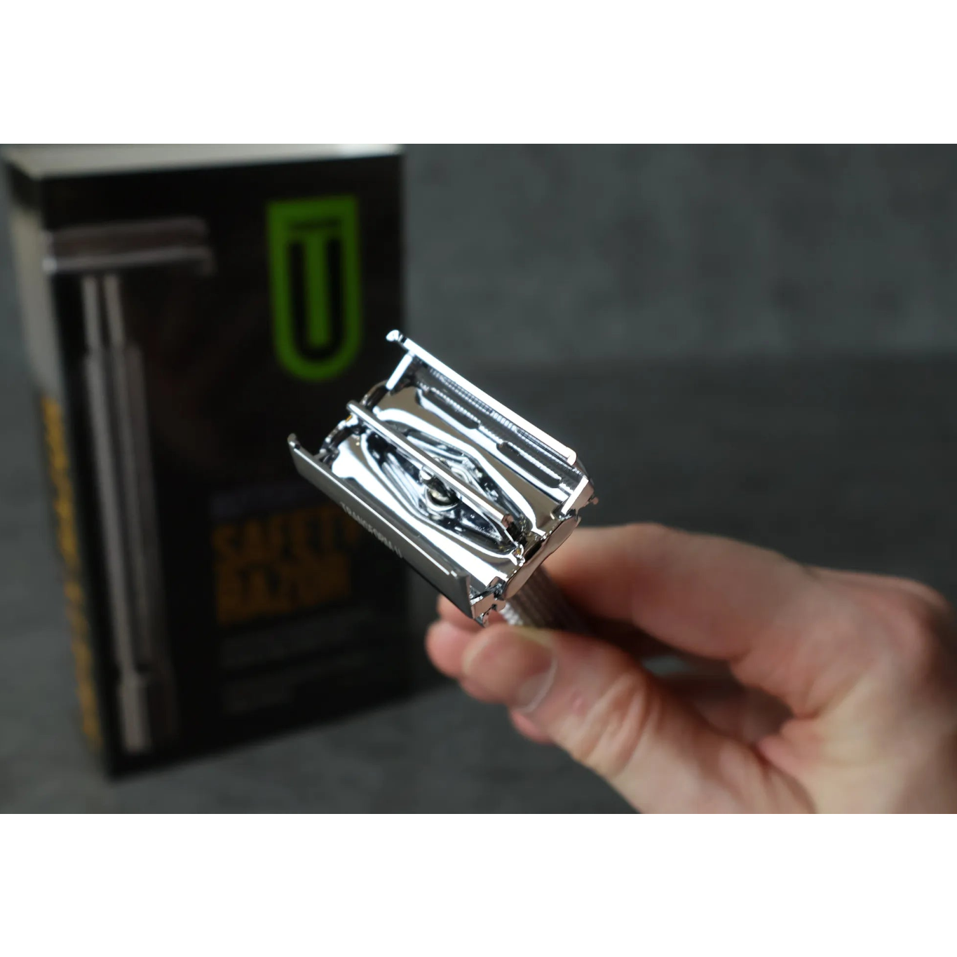 Hand holding a open safety razor with a blurred background