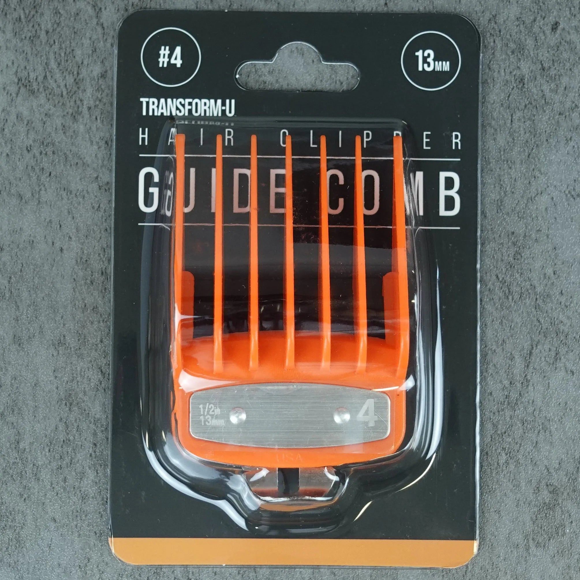 Orange guide comb in packaging on a gray concrete surface