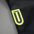 Close-up of a black fabric with a yellow logo on a gray background