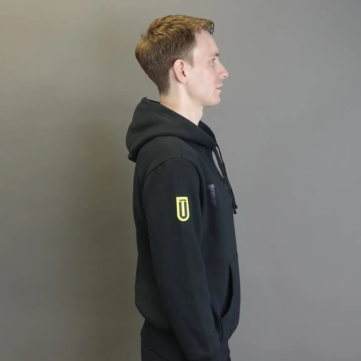 man wearing a black hoodie with a TRANSFORM-U logo