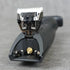 Body groomer trimmer head on a gray surface with a blurred background