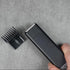 Hair trimmer with comb on a gray surface