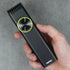 Hand holding a black hair trimmer against a gray background