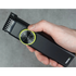 Hand holding a black hair trimmer with a yellow guide comb dial on a gray background