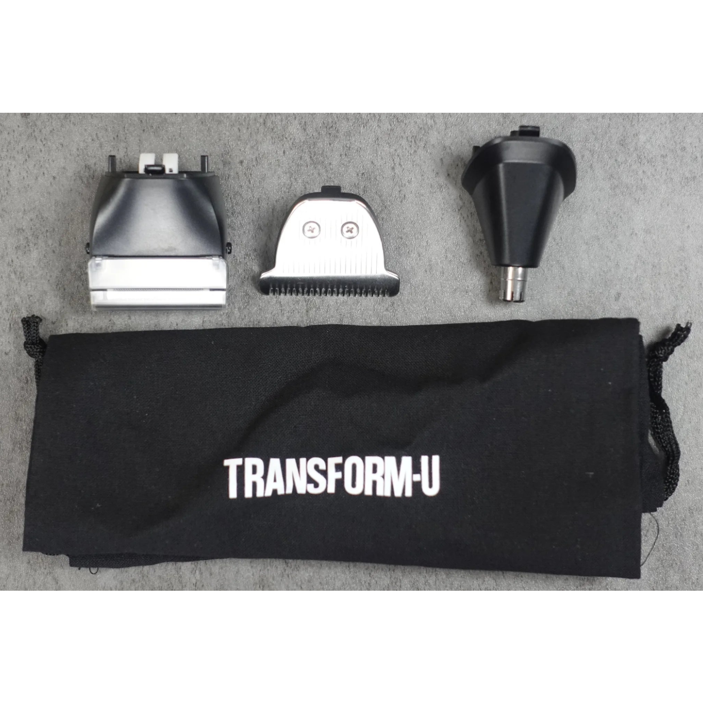 Hair trimmer components on a 'TRANSFORM-U' branded black pouch against a gray background