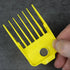 Yellow magnetic guide comb held by a hand against a dark background