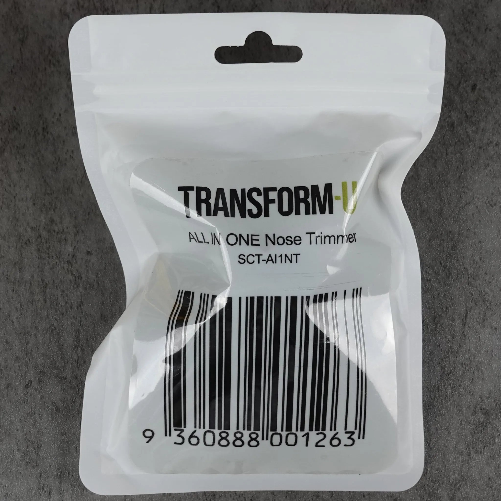 Clear plastic nose trimmer packaging with 'Transform-U' branding on a gray background