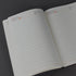 Open notebook with lined pages on a dark background