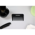 Black comb with 'TRANSFORM-U' branding on a white surface with grooming items.