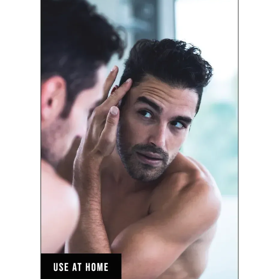 a man looking at his hair in the mirror with text overlay displaying 'use at home'