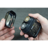 Two hands holding a travel shaver and its charging case against a gray background
