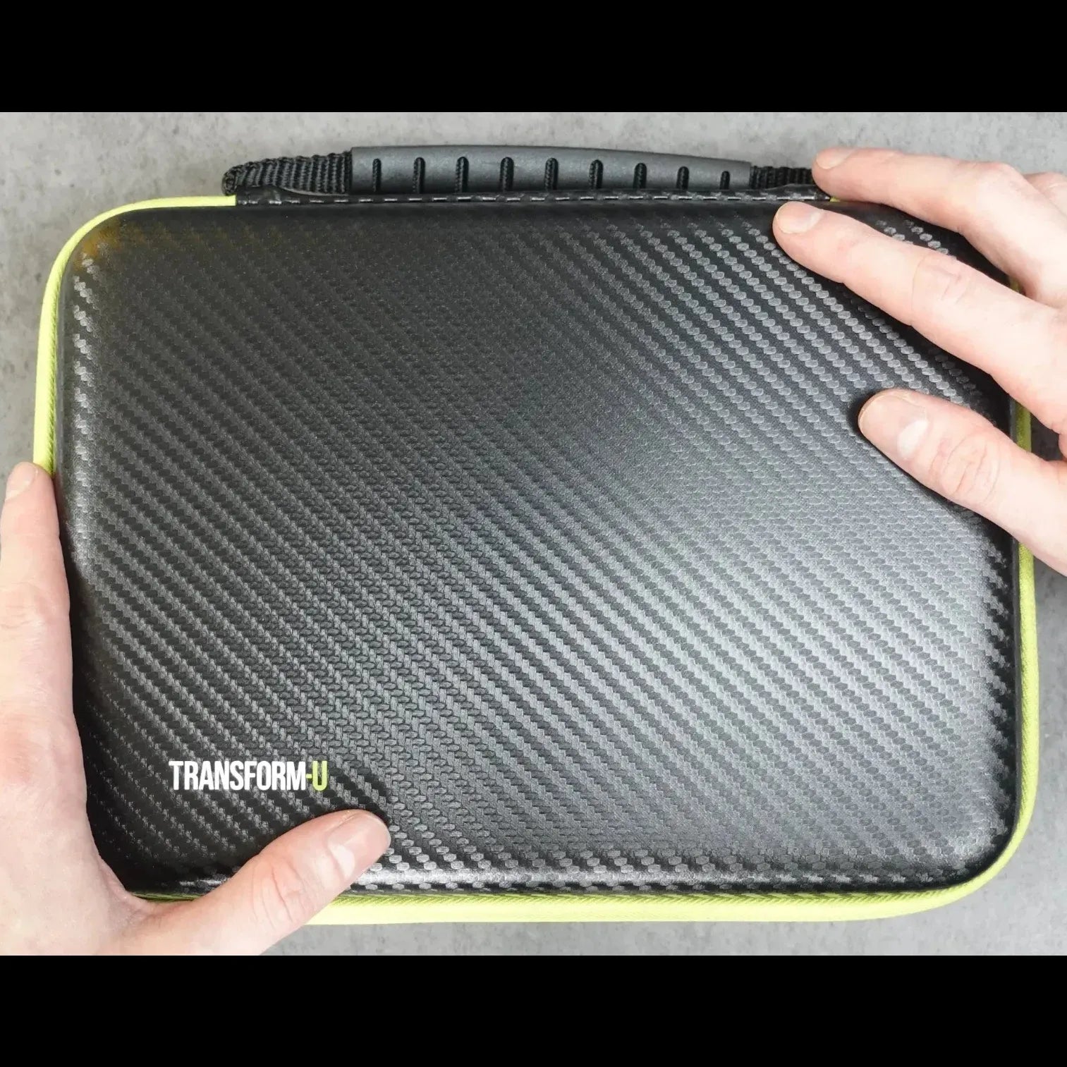 Carbon fiber texture case with 'Transform U' branding held by hands on a gray background