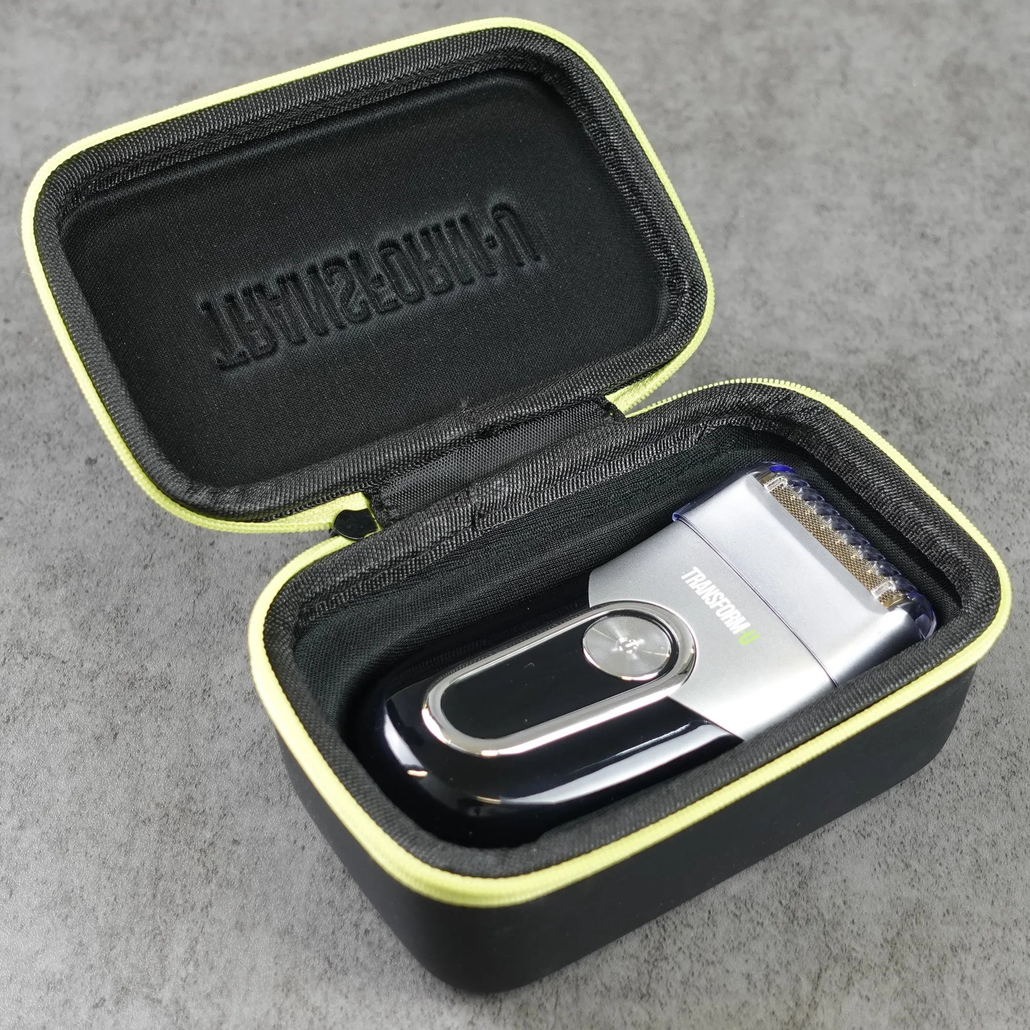 Electric travel shaver in a black carrying case on a gray surface