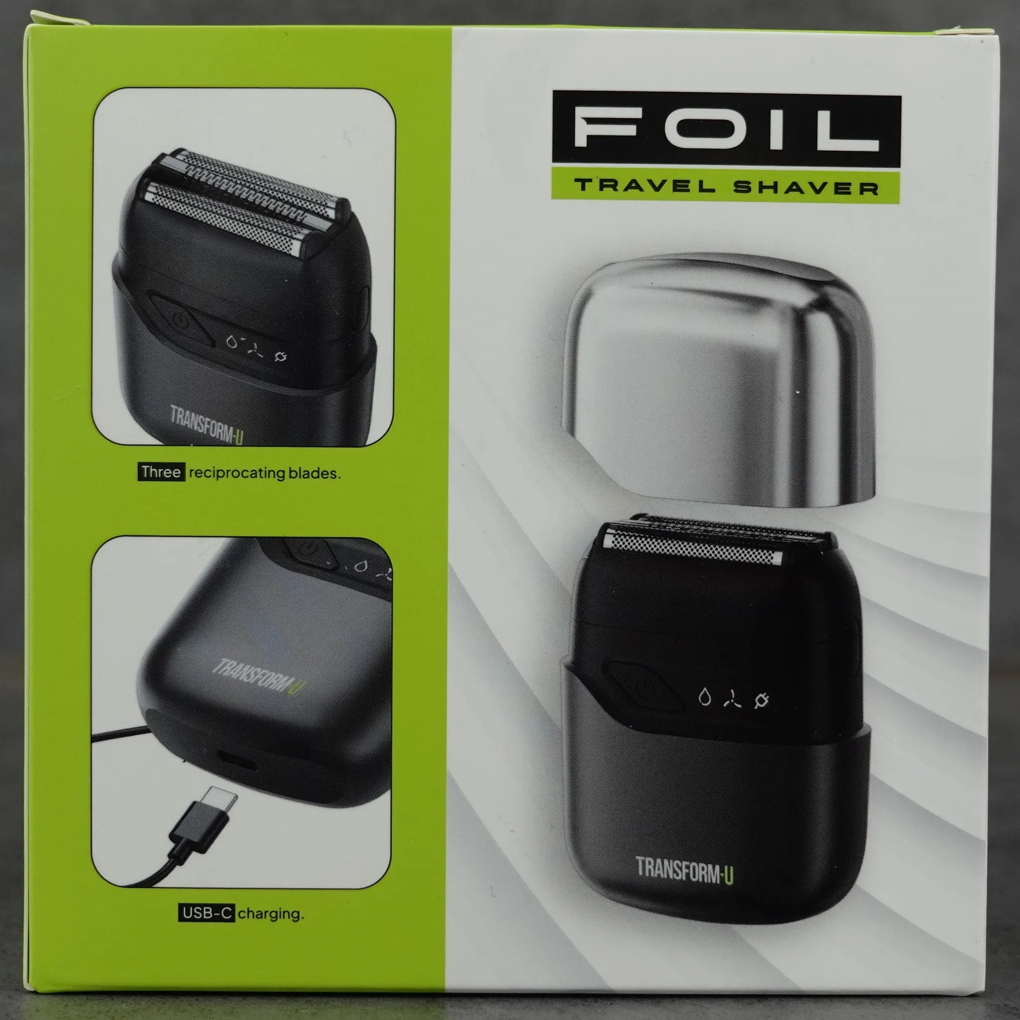 Box packaging of a travel shaver with foil and charging cable on a gray background