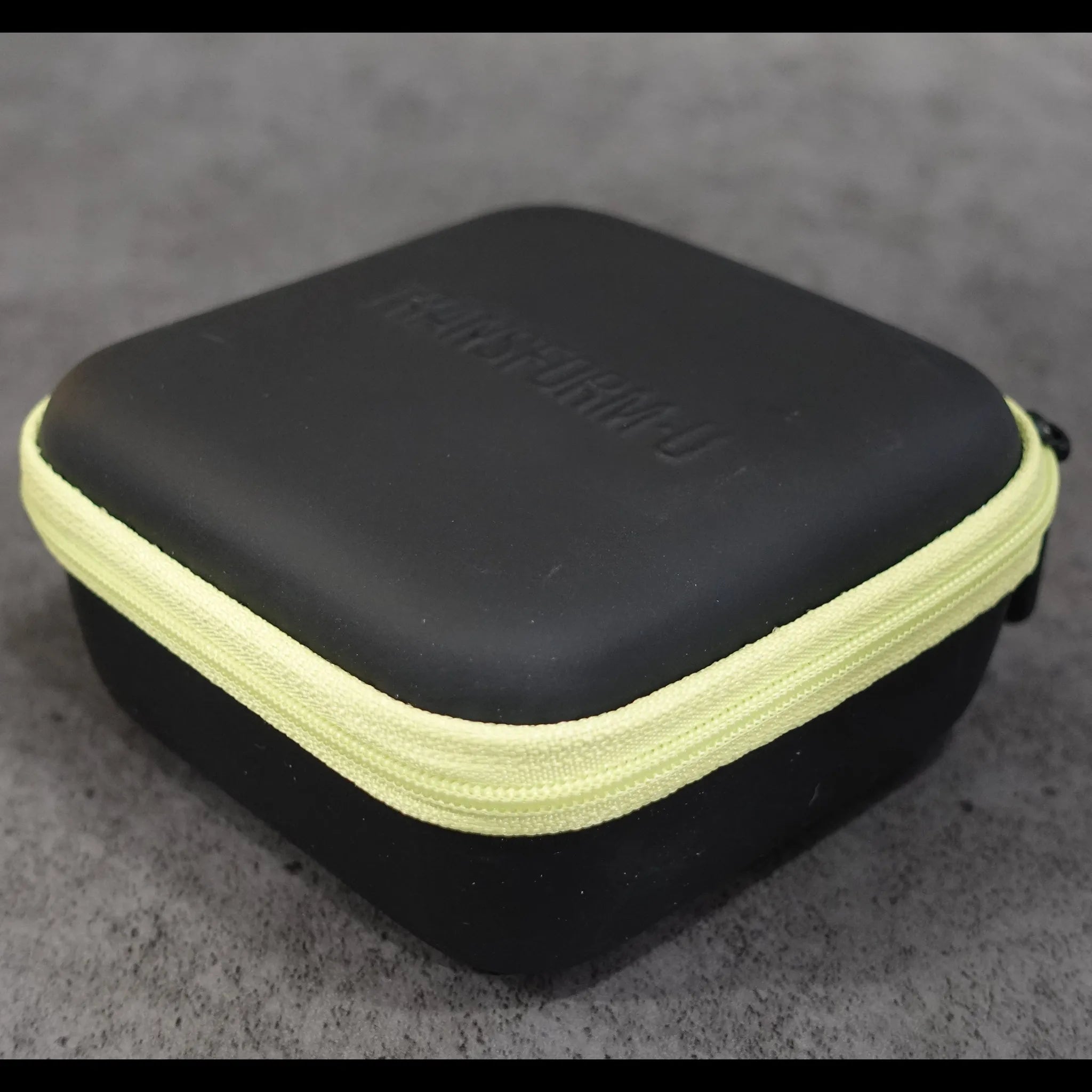 Black and green hard-shell case on a gray surface