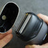 Electric shaver held by a hand with a blurred background