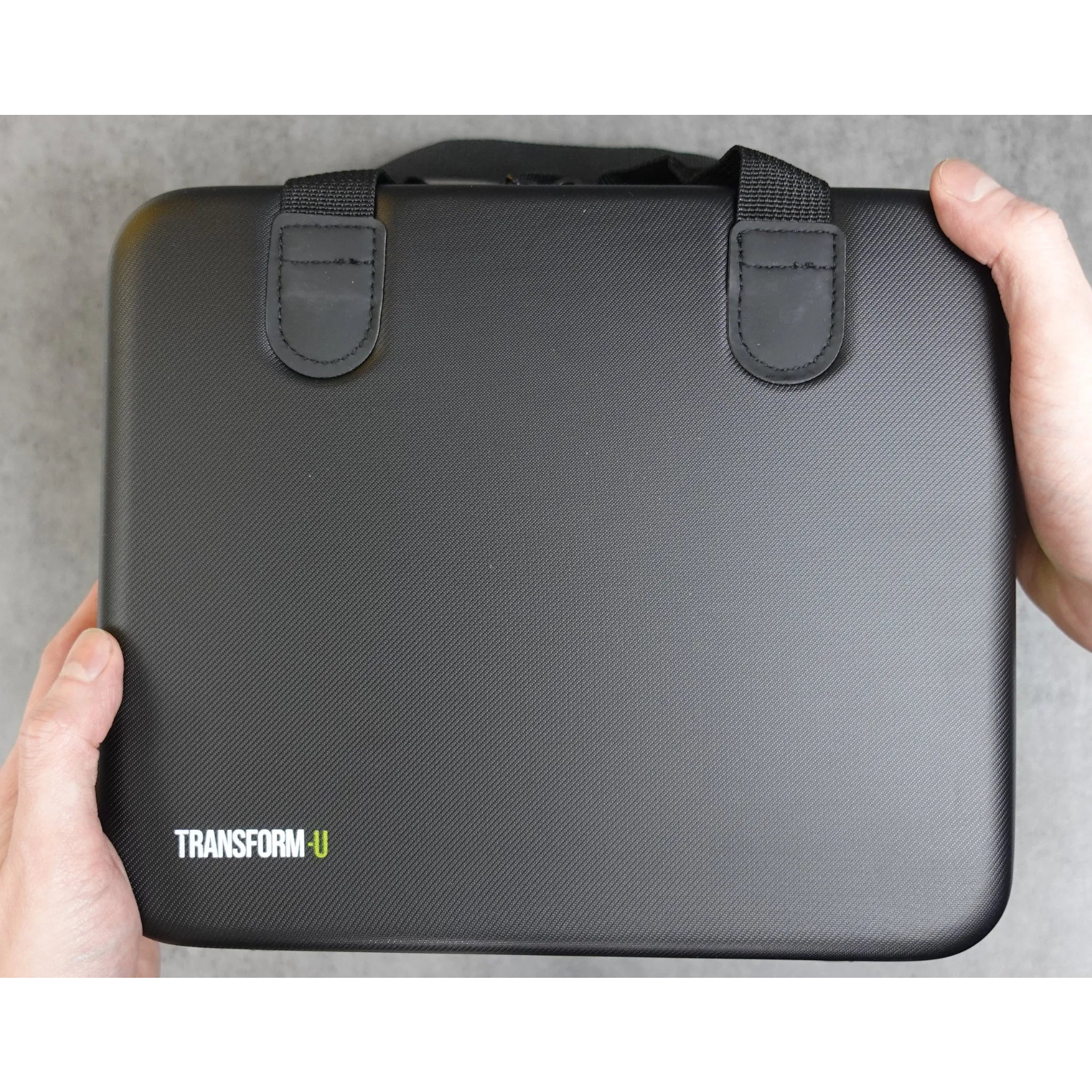 Black grooming case held by a person on a gray surface with 'Transform-U' branding.