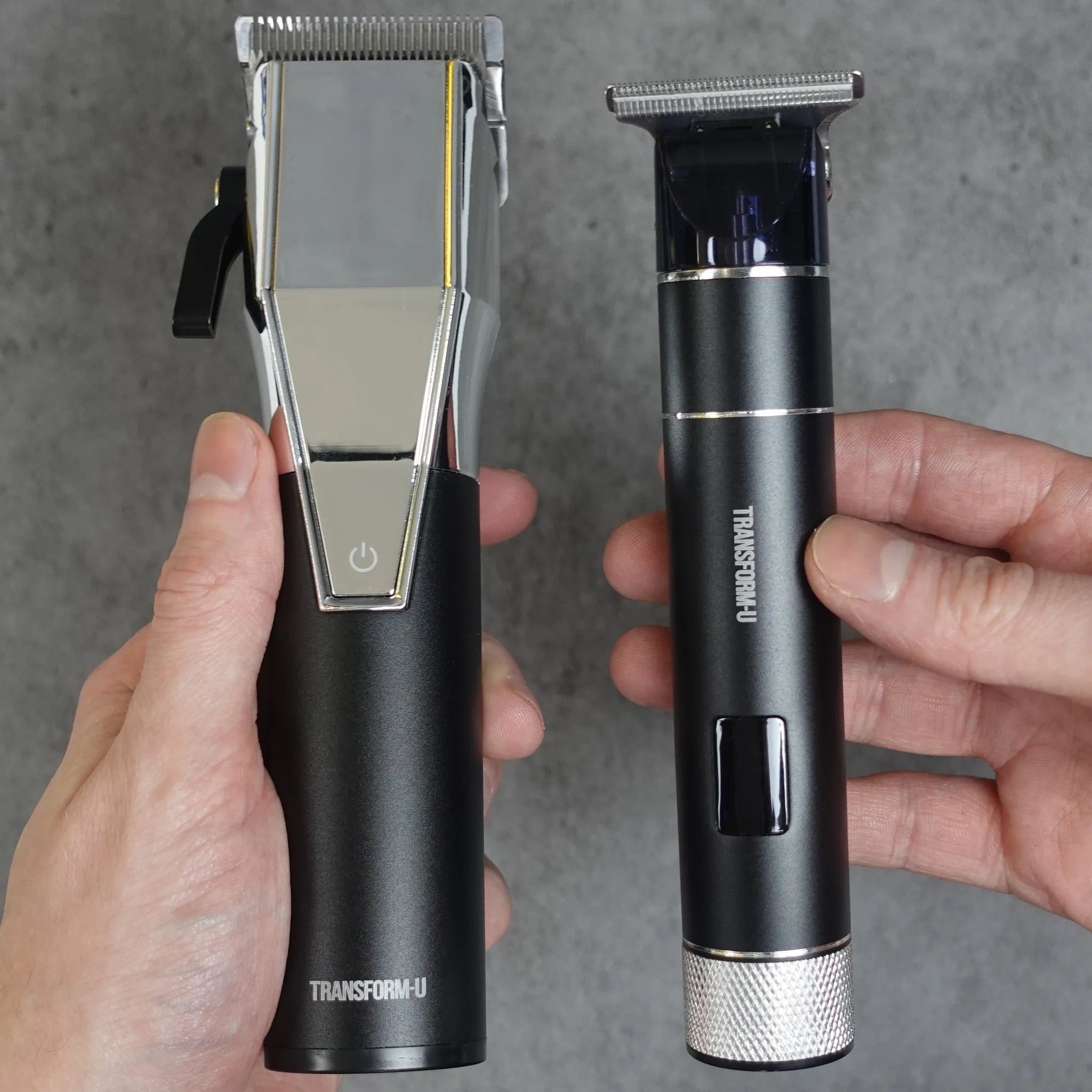 Two electric grooming devices held in hands against a gray background
