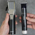 Two electric grooming devices held in hands against a gray background